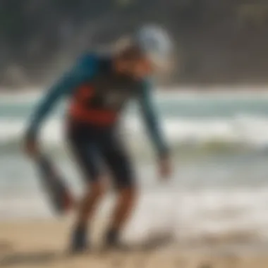 Kiteboarder adjusting gear on the beach with ocean waves