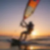 A serene kiteboarding scene at sunset showcasing the vibrant hues of the sky reflecting on the ocean's surface.