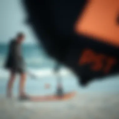 A kitesurfer inspecting a used kite on the beach