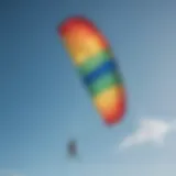 A vibrant ultralight kite soaring high against a clear blue sky