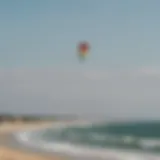 A vibrant kite soaring against the backdrop of Cape Cod's coastline